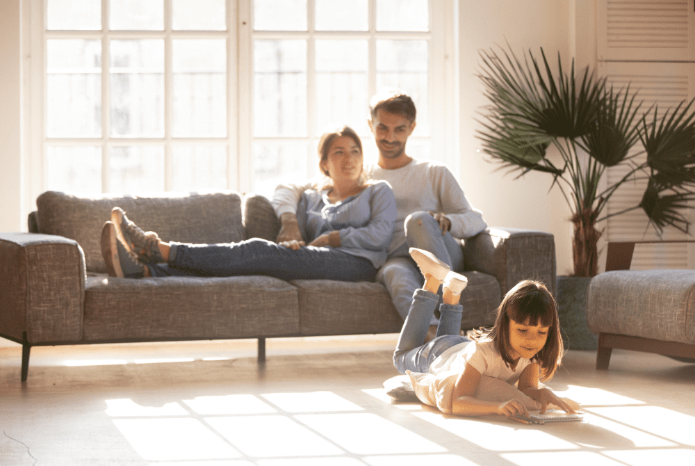 family of 3 sitting on couch depicting tenants